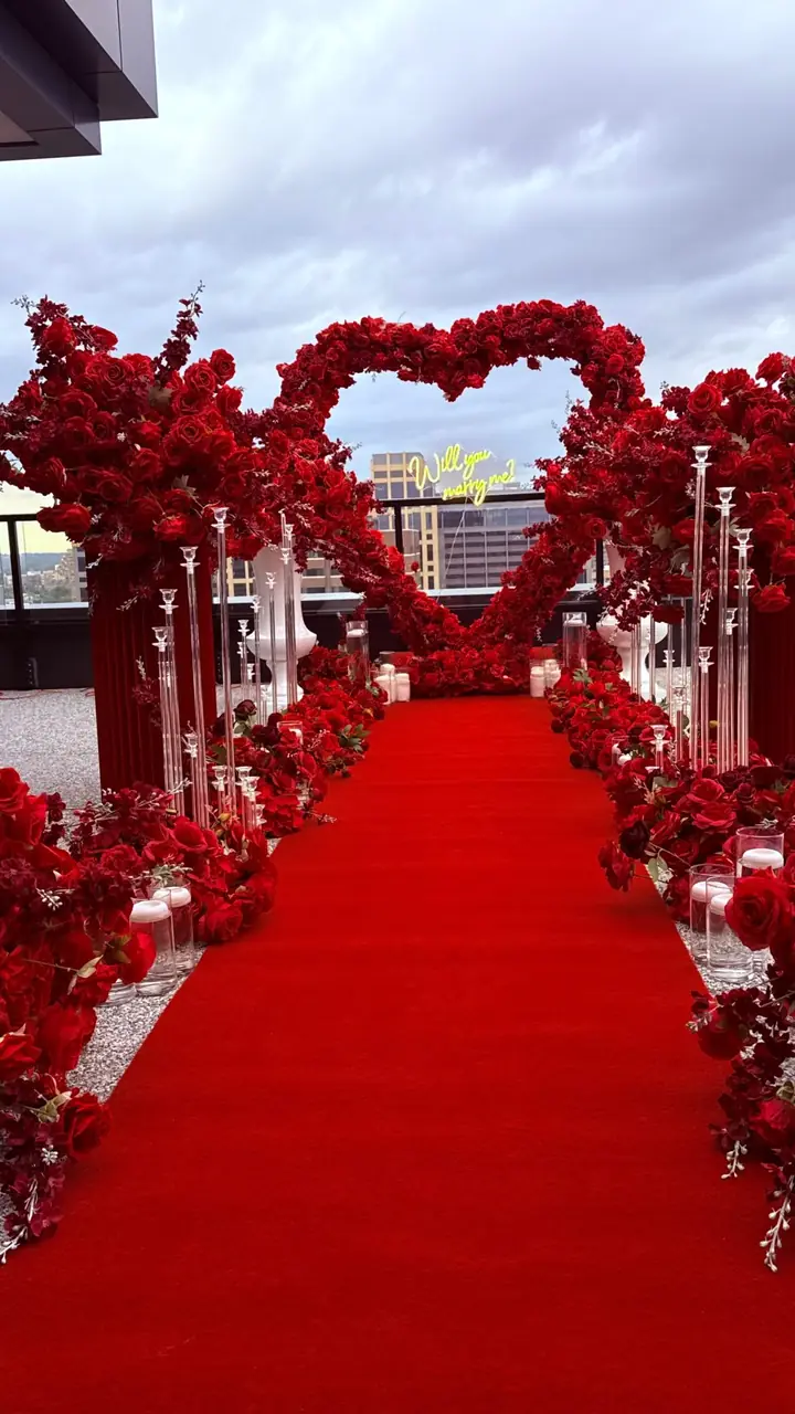 Red rose aisle leading to a heart arch
