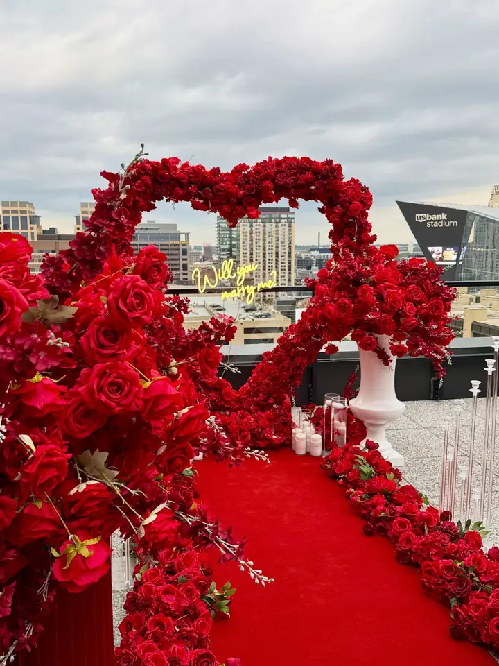Red rose heart arch on a rooftop at sunset